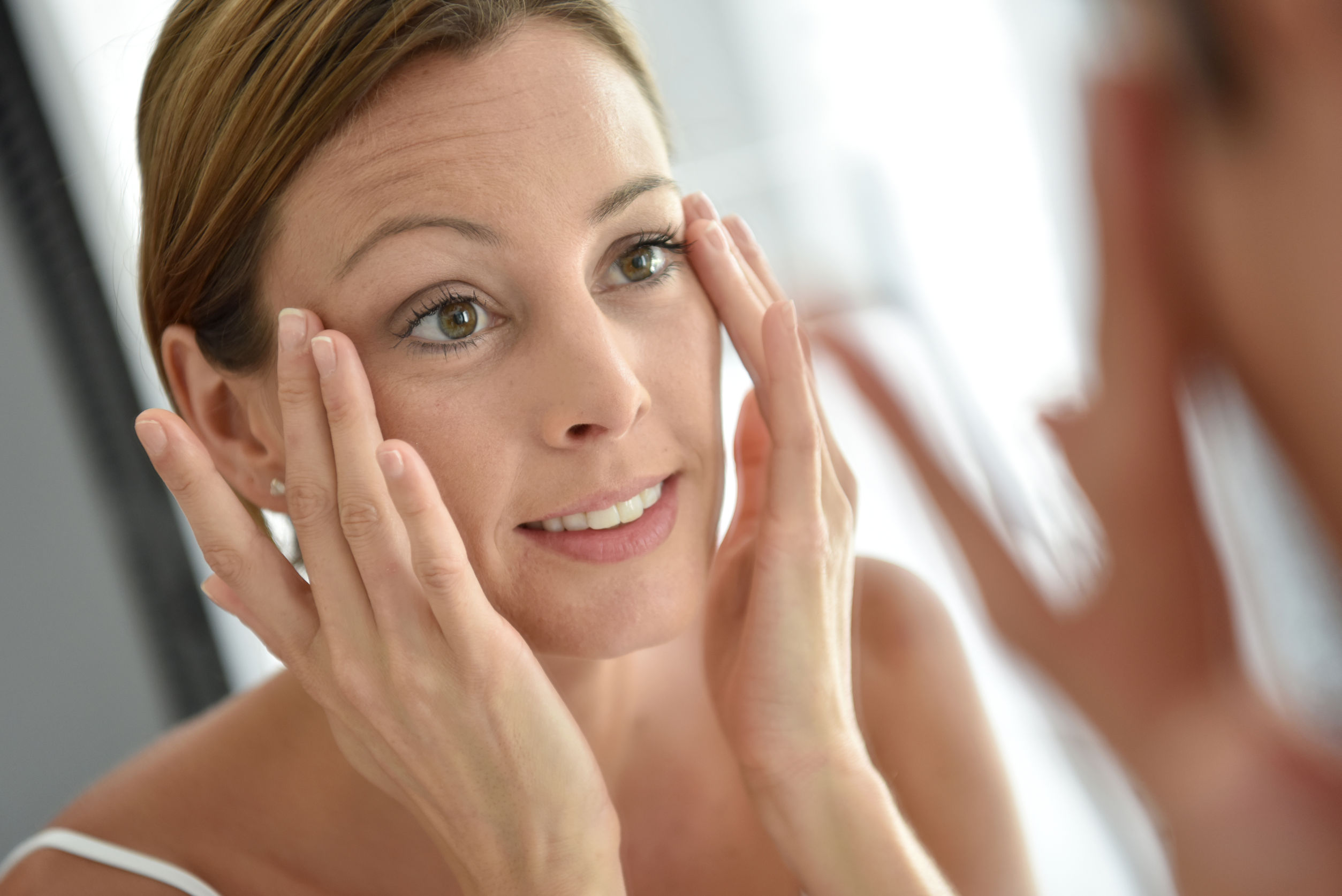 50065572 – woman applying facial cream on her face